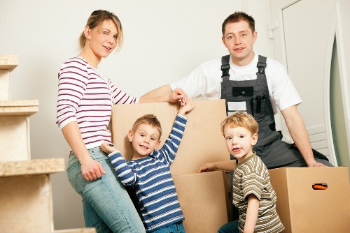 Professional movers transporting furniture through a London street