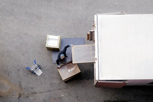 Professional movers carrying household items in a London apartment building