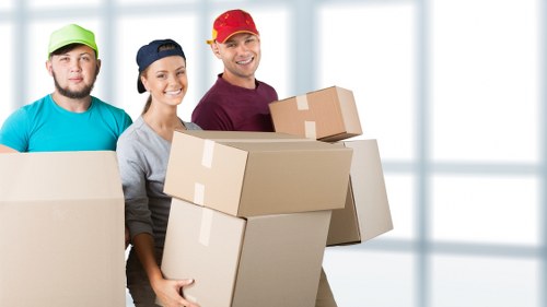 Professional movers carrying furniture from a flat in London