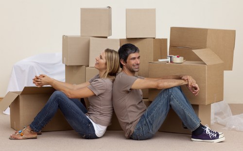 Removal team carrying boxes through a London property staircase